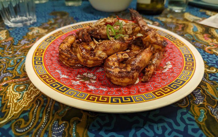 Intricately patterned plate with food on it on a colourful tablecloth