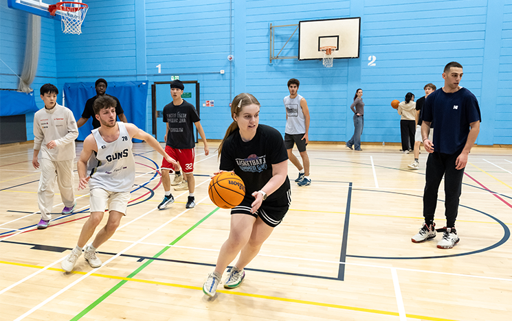 Students playing basketball in the sports hall