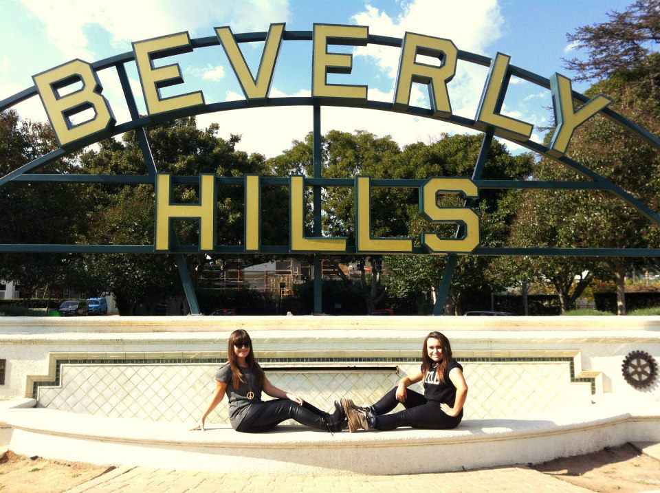 Two students sat in front of the Beverly Hills sign