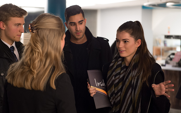 A Sussex student intern talking to a group of colleagues