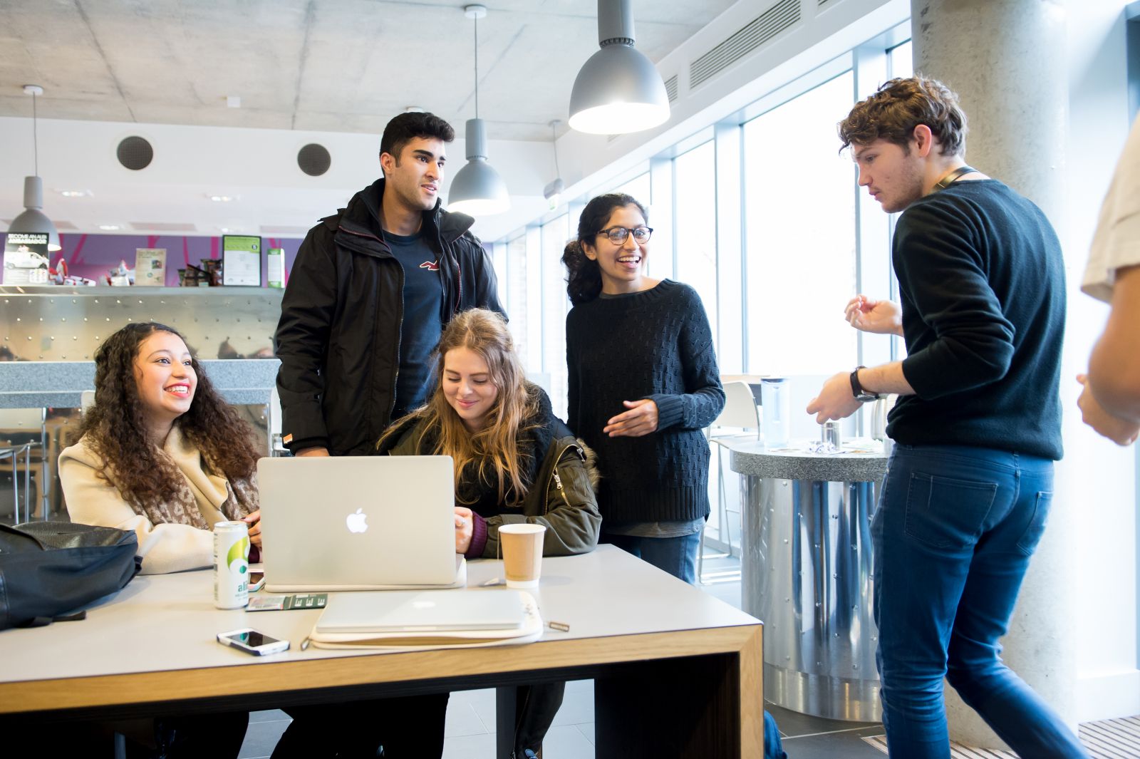 Students gathered around a table in a cafe on campus