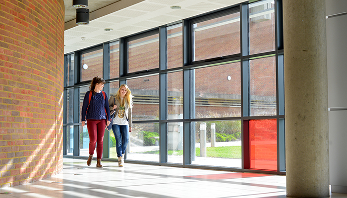 Two PhD students walk through the School of Business, Management and Economic's Jubilee building at the University of Sussex.