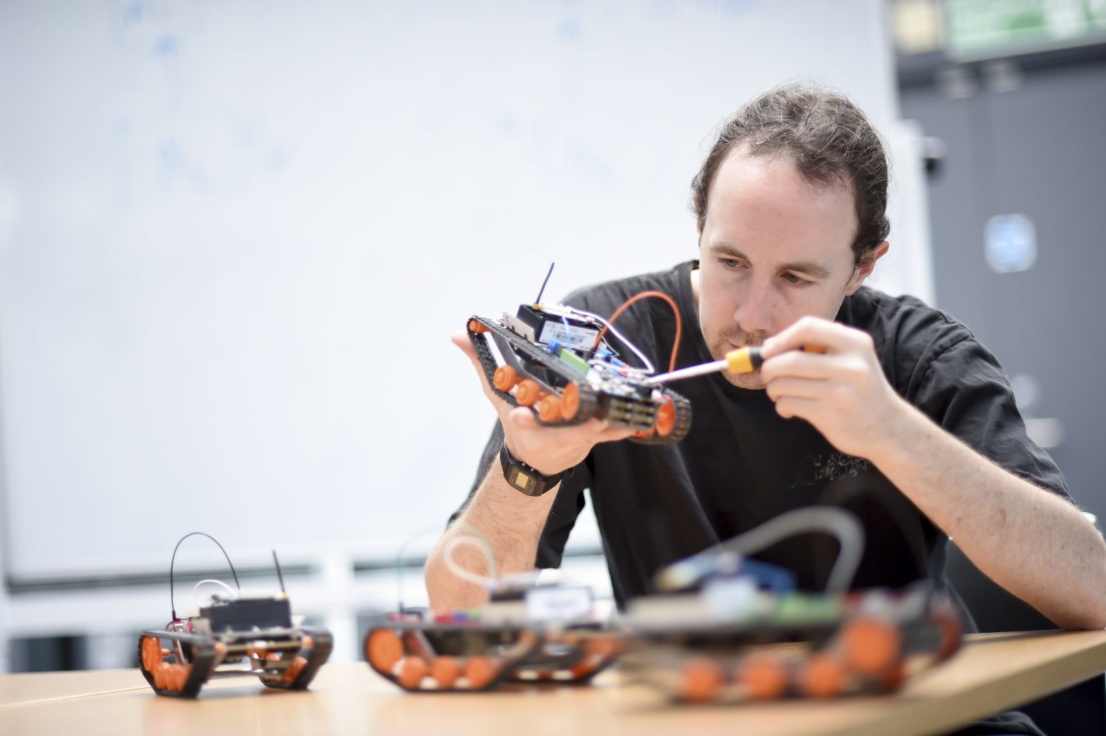 A PhD student works on mini-robots for his robotics project at the University of Sussex