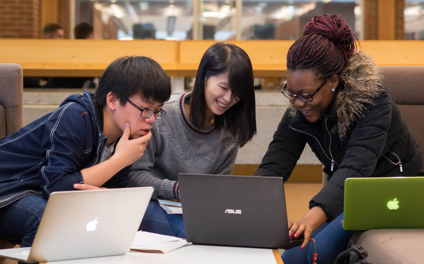 PhD students gather around laptops as they work together on a project at the University of Sussex