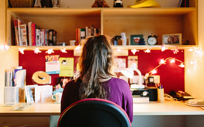 student faces desk in student accommodation