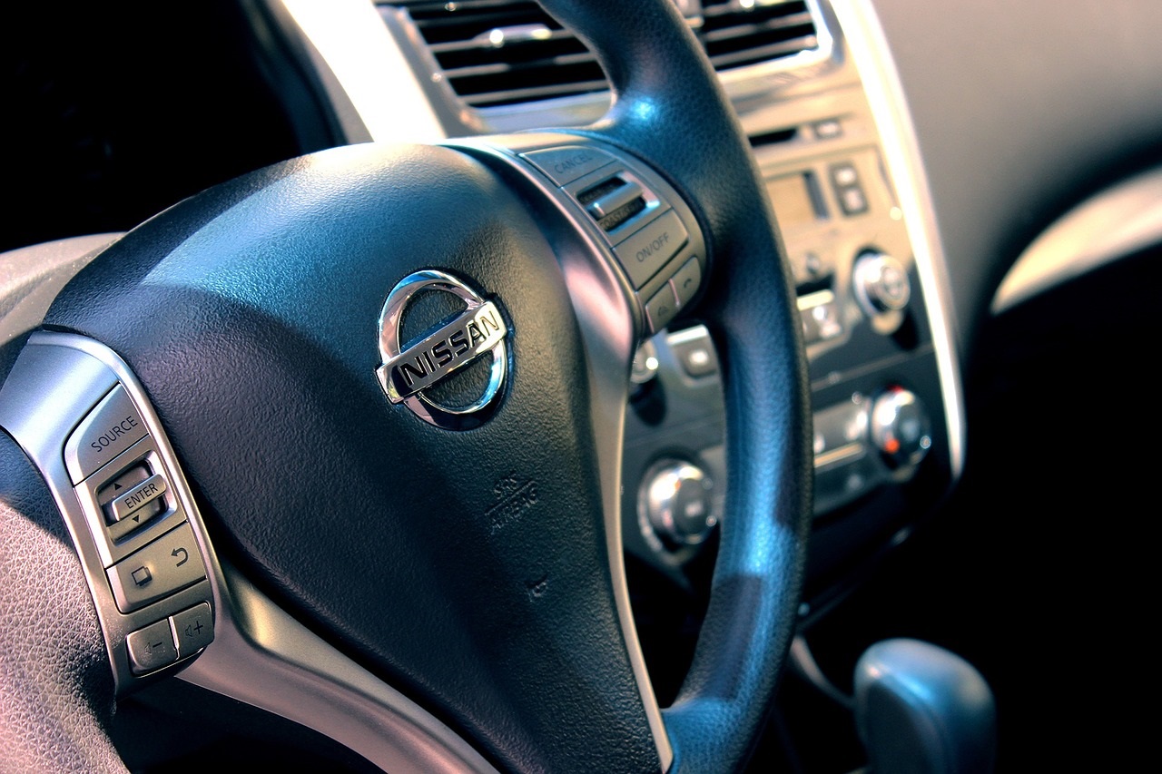 A close-up photo of the steering wheel of a Nissan car