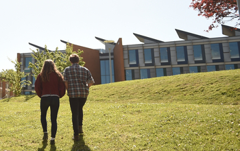 Students walking through campus with the sun shining down