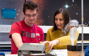 A teacher showing a youngster how some science equipment works