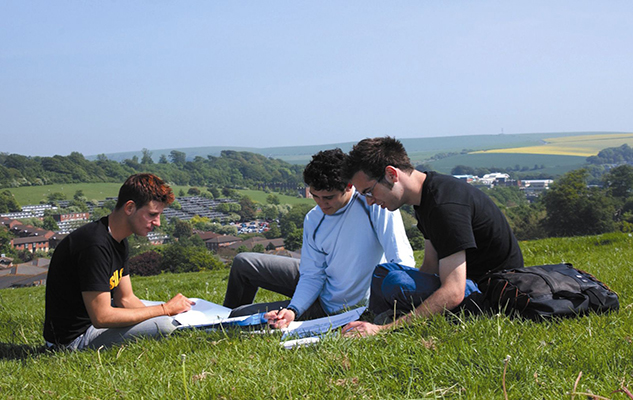 Students work on land overlooking campus