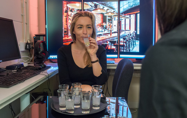 An experiment to see how drinking alcohol can affect the brain. Here a person drinks alcohol while being monitored by researchers.