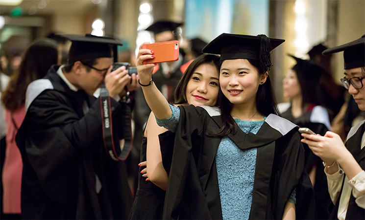 Two students take their picture at a ceremony in China