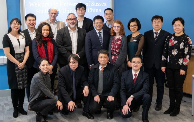 icon A delegation of staff posing for a photo with Saul Becker