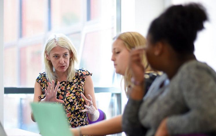 ICON: two students chatting informally to a staff member