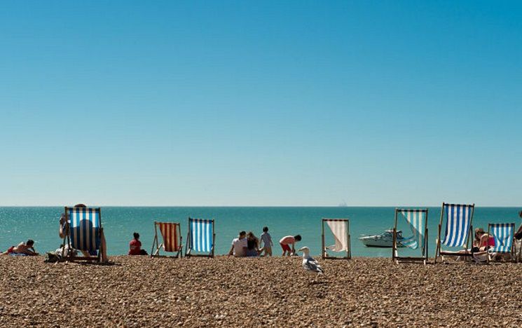 ICON: sunny day on Brighton beach with two deckchairs