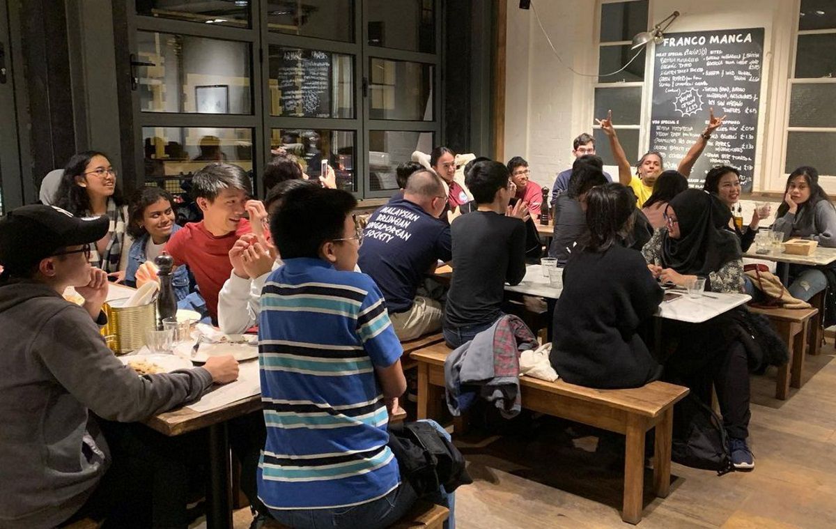 A large group of students in a restaurant at night