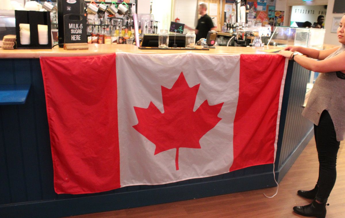 a big Canadian flag is draped over the front of the Student Bar