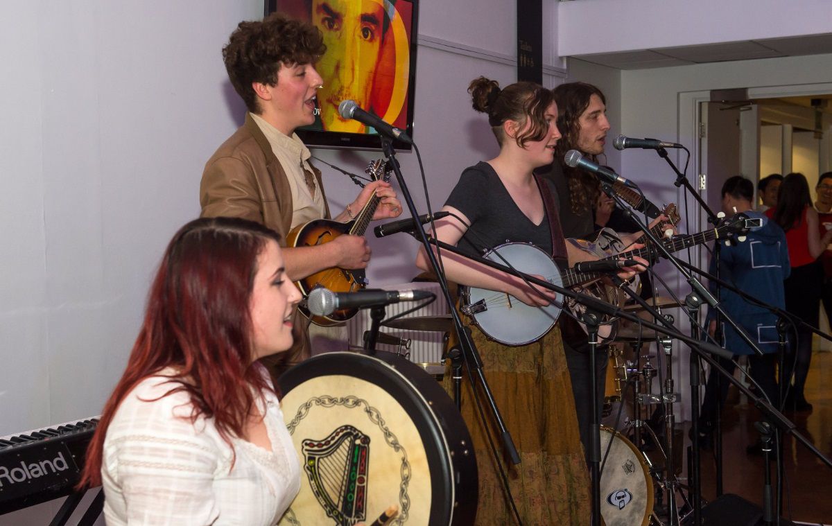 Folk musicians play to a crowd in a bar