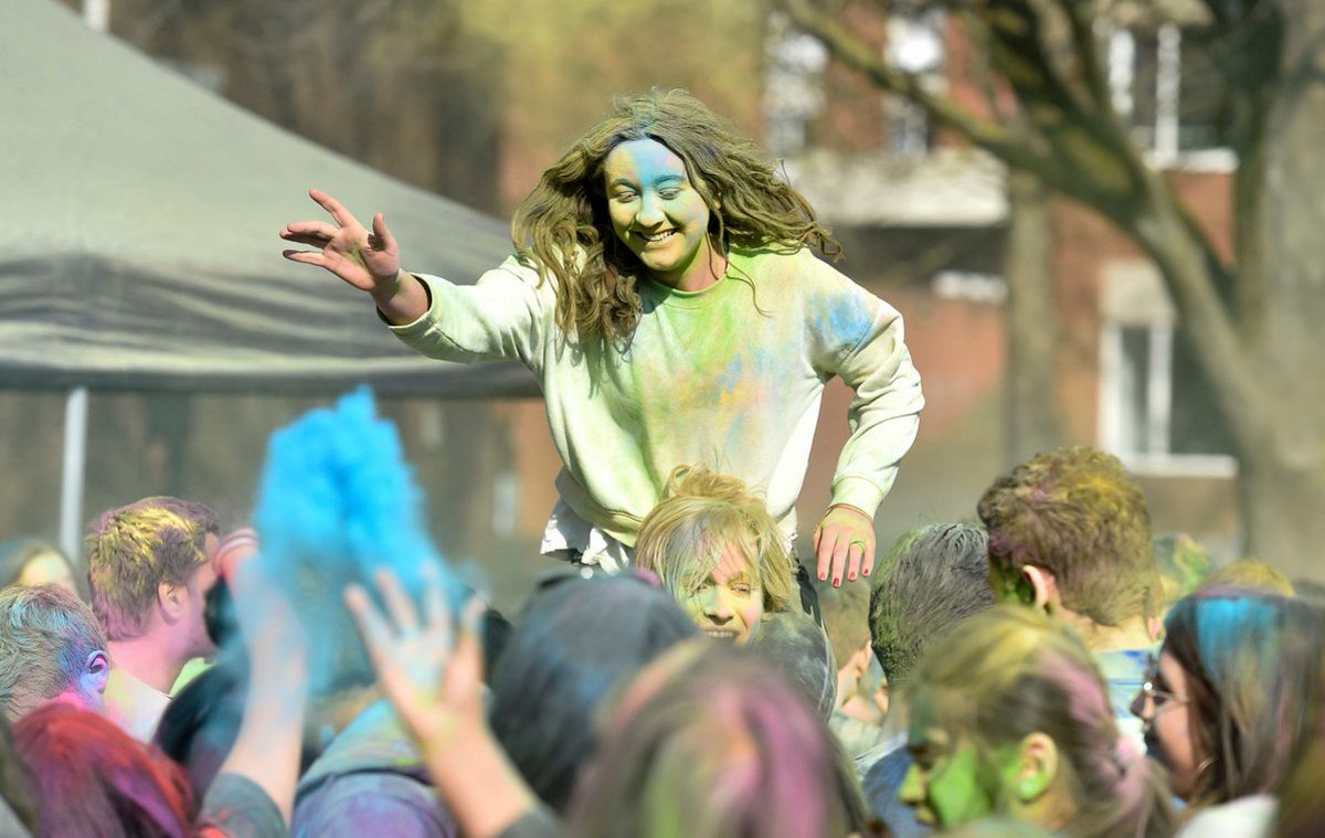 Students celebrating Holi covered in coloured powder