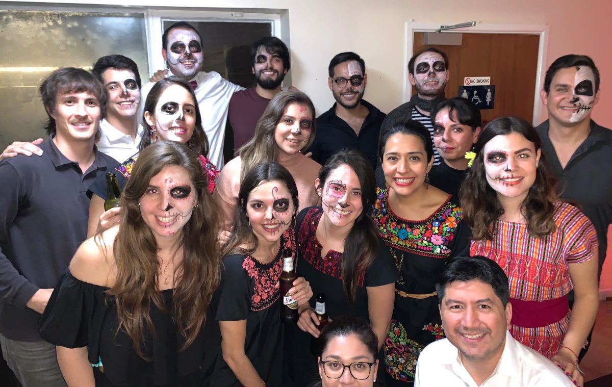 Several students in Day of the Dead outfits and decorations pose for the camera
