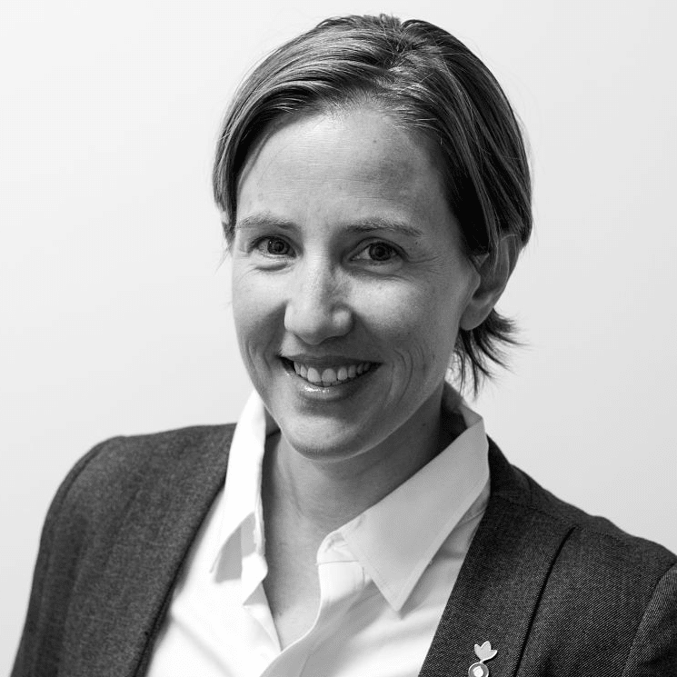 black and white photo of woman smiling to camera wearing officewear