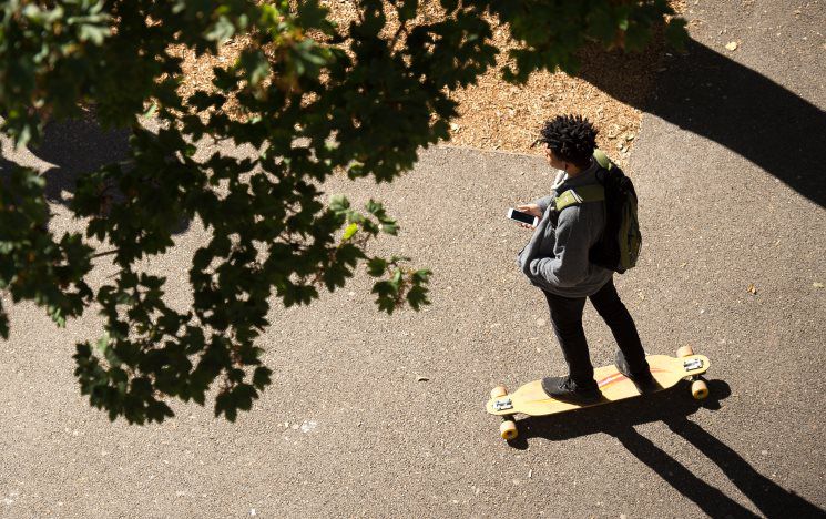 Top down shot of a student skateboarding on campus