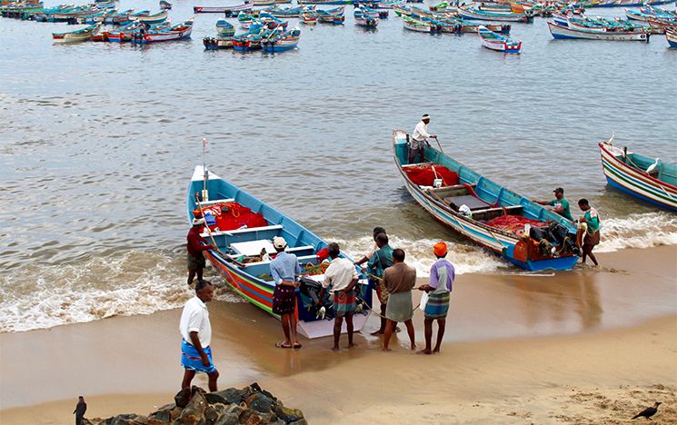 Local people setting up their fishin boats on a sandy coast