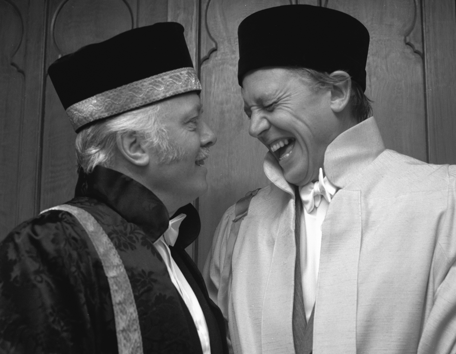 Black and white photograph of Lord Richard Attenborough and Richard E Grant wearing formal ceremonial dress at a University of Sussex graduation ceremony..
