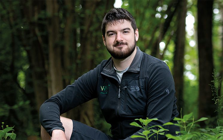 Kieran crouching down in the woods