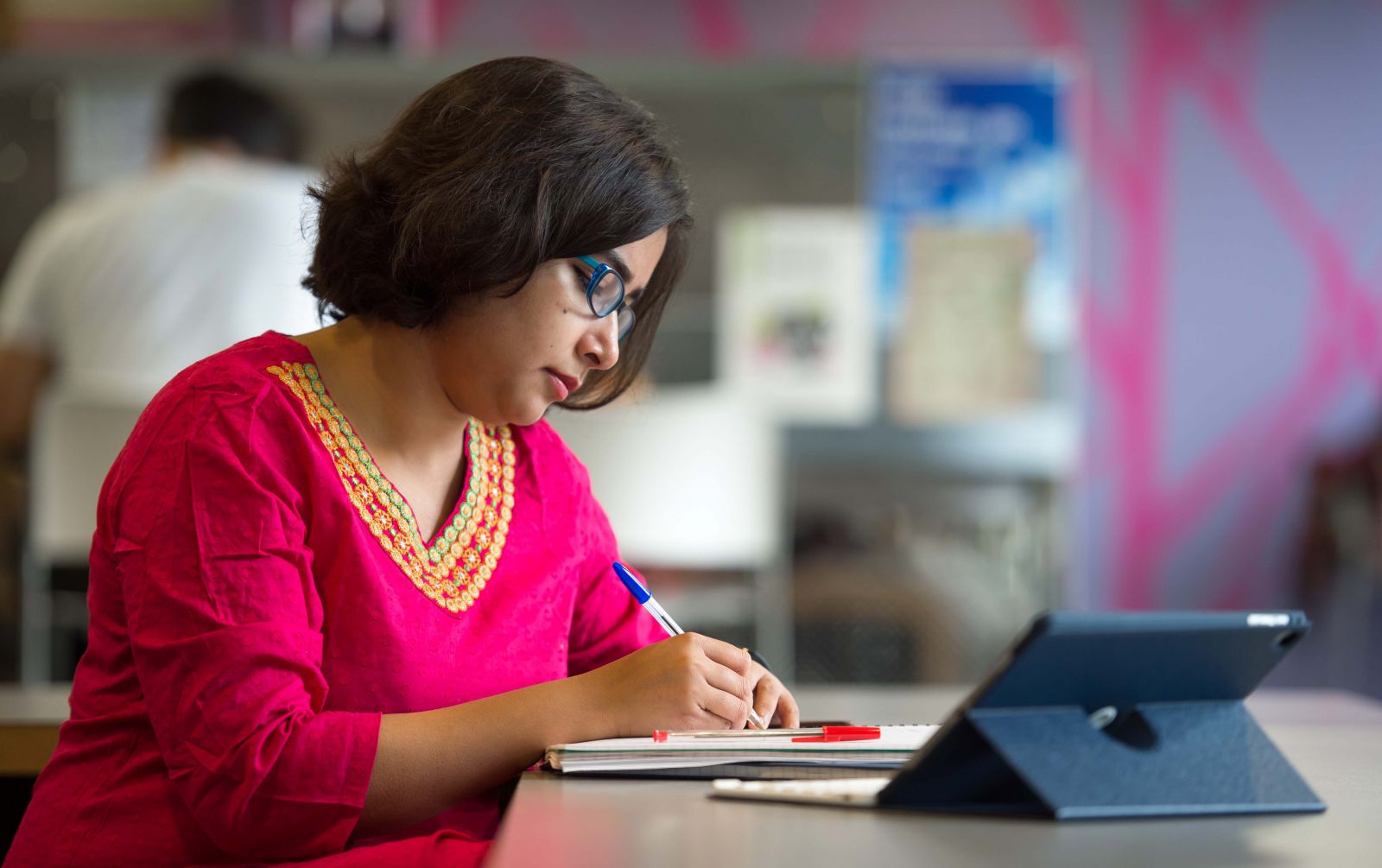 Woman studying at desk with an iPad