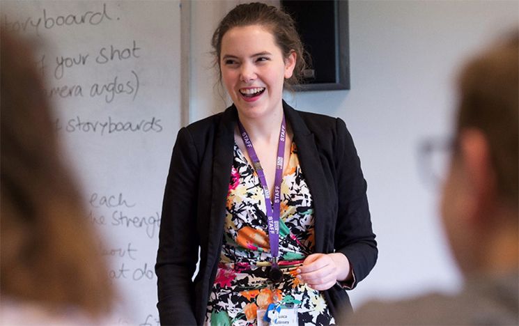 A happy teacher stood at the front of the class