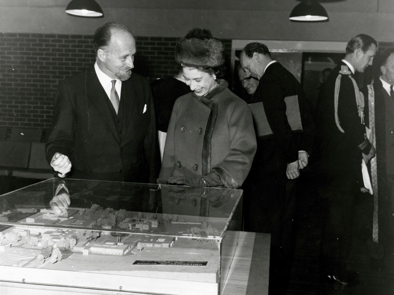 During a visit to open the campus library on 13 November 1964, Her Majesty talks with Basil Spence as he shows her a model of campus, which is still on display in Bramber House.