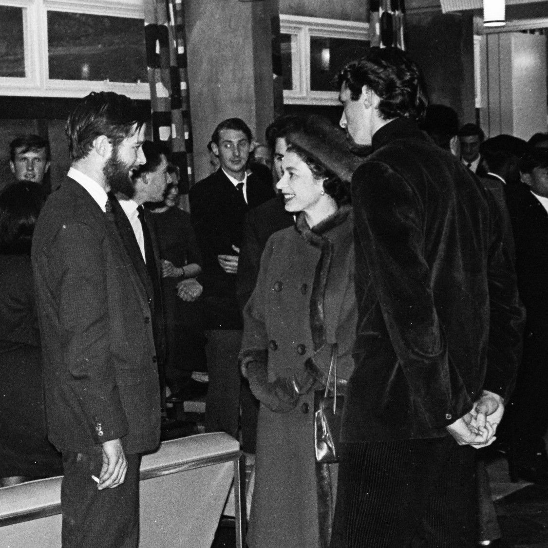 Her Majesty the Queen talks to a student in a building on campus