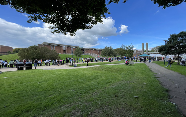 University campus showing greenery on campus (grass) and students