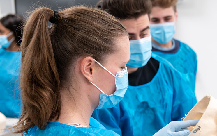 Medical staff talking and looking at apparatus in an operating theatre