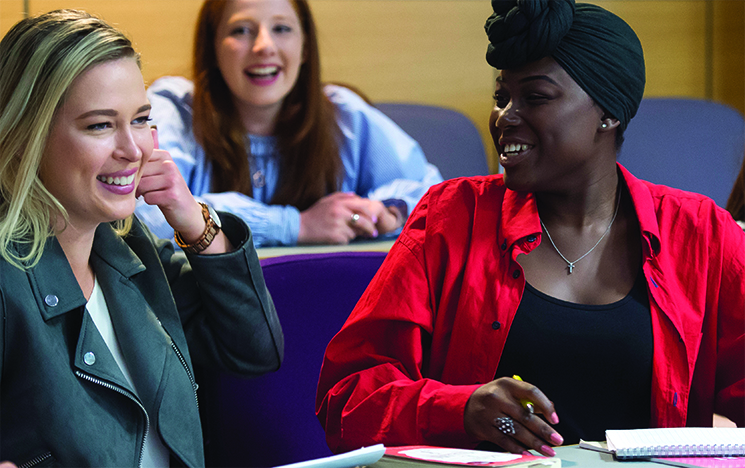 Students discussing a topic in a lecture theatre at the University of Sussex