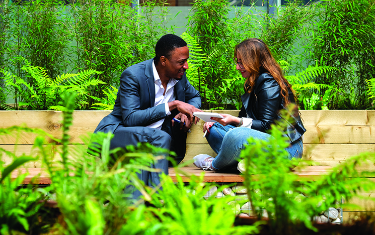 A business man and a colleague discussing a topic in a meeting in an outside space at the University of Sussex