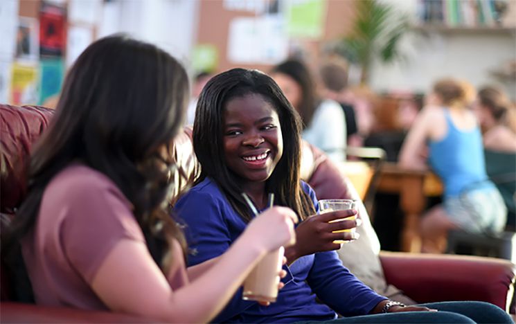 
Students smiling and enjoying soft drinks