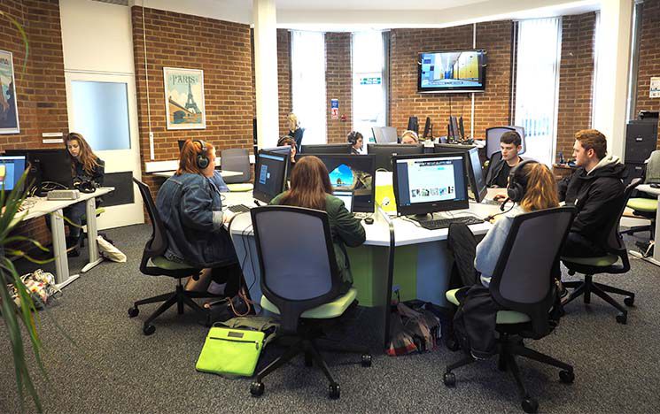 
A group of students sat around a central computer area in the resource centre