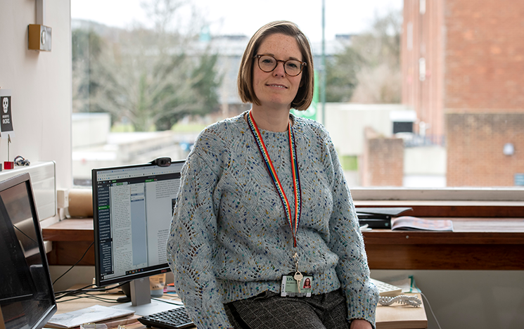 

Image of Kate Howland sat on desk