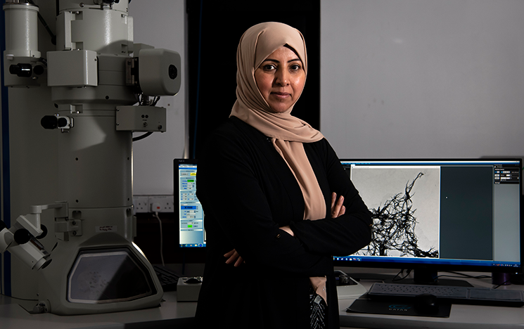 Image of Youssra Al-Hilaly in front of computer and machinery