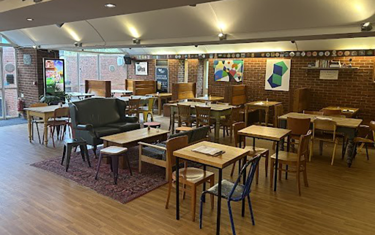 The counter and seating area with confectionary on the counter and nice lighting