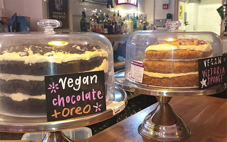 The counter and seating area with confectionary on the counter and nice lighting