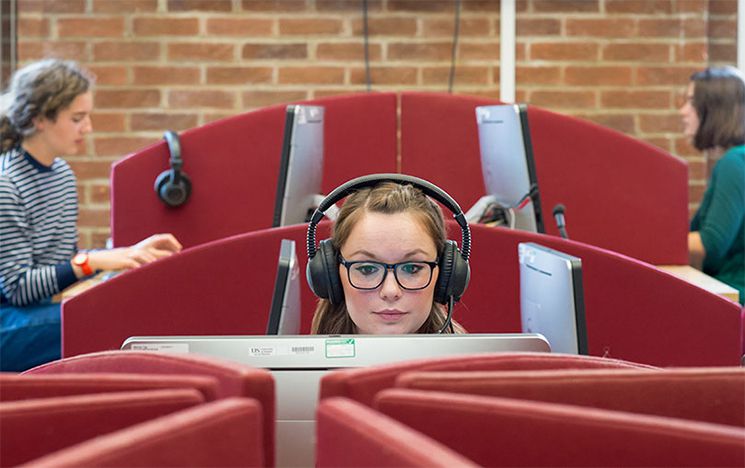 Student learning at a computer with headphones on
