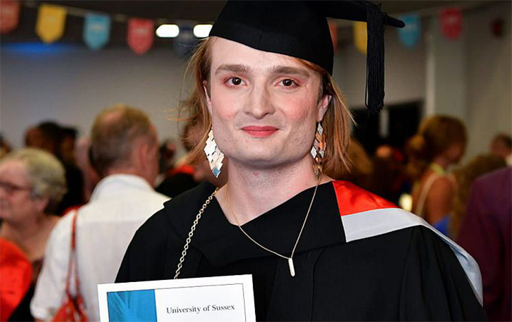 A student holding a certificate for an award at a graduation ceremony