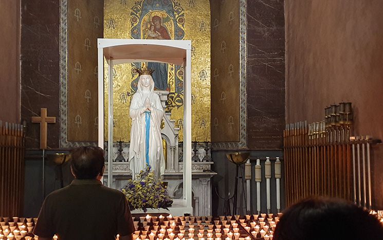 Pilgrims praying in the chapel of Our Lady, Lourdes sanctuary.