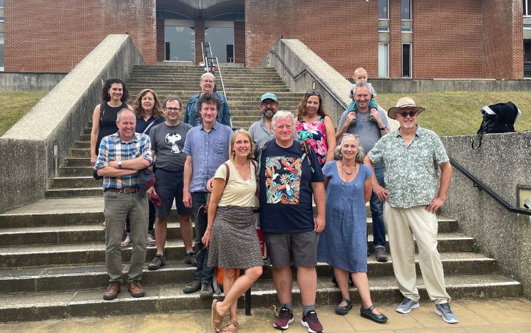 A group of Sussex alumni on the steps outside the Library on campus.