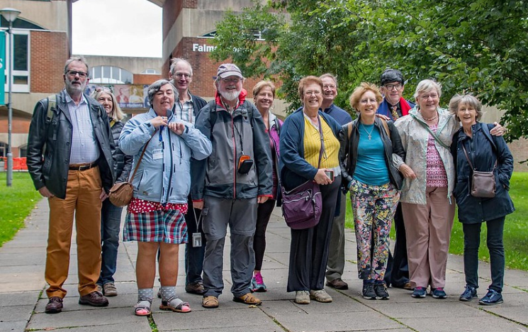 A group of alumni standing outside Falmer House on campus