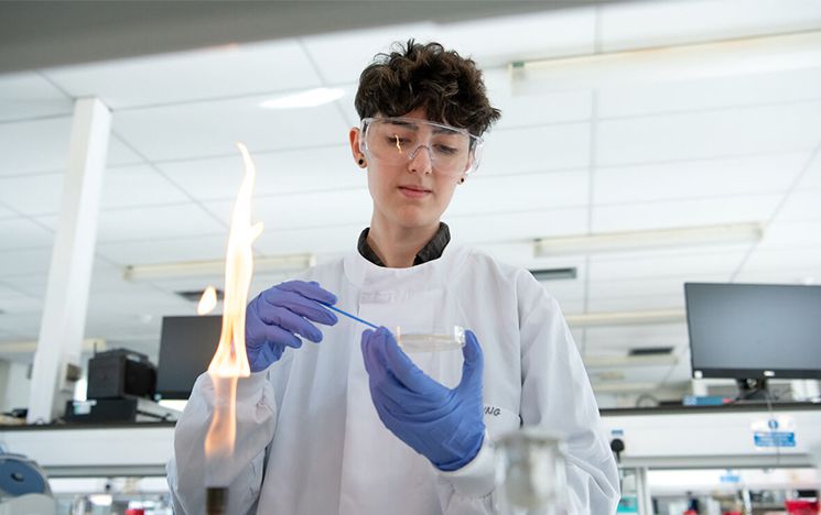 Biology student doing experiments in one of Sussex’s laboratories, working with a Bunsen burner