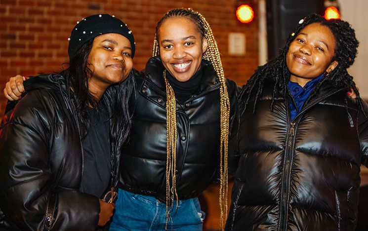 Three women wearing jackets