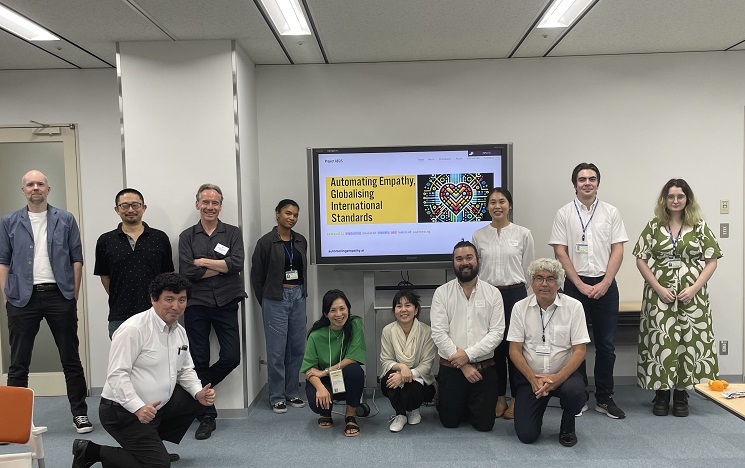Group of people in front of a classroom whiteboard smiling